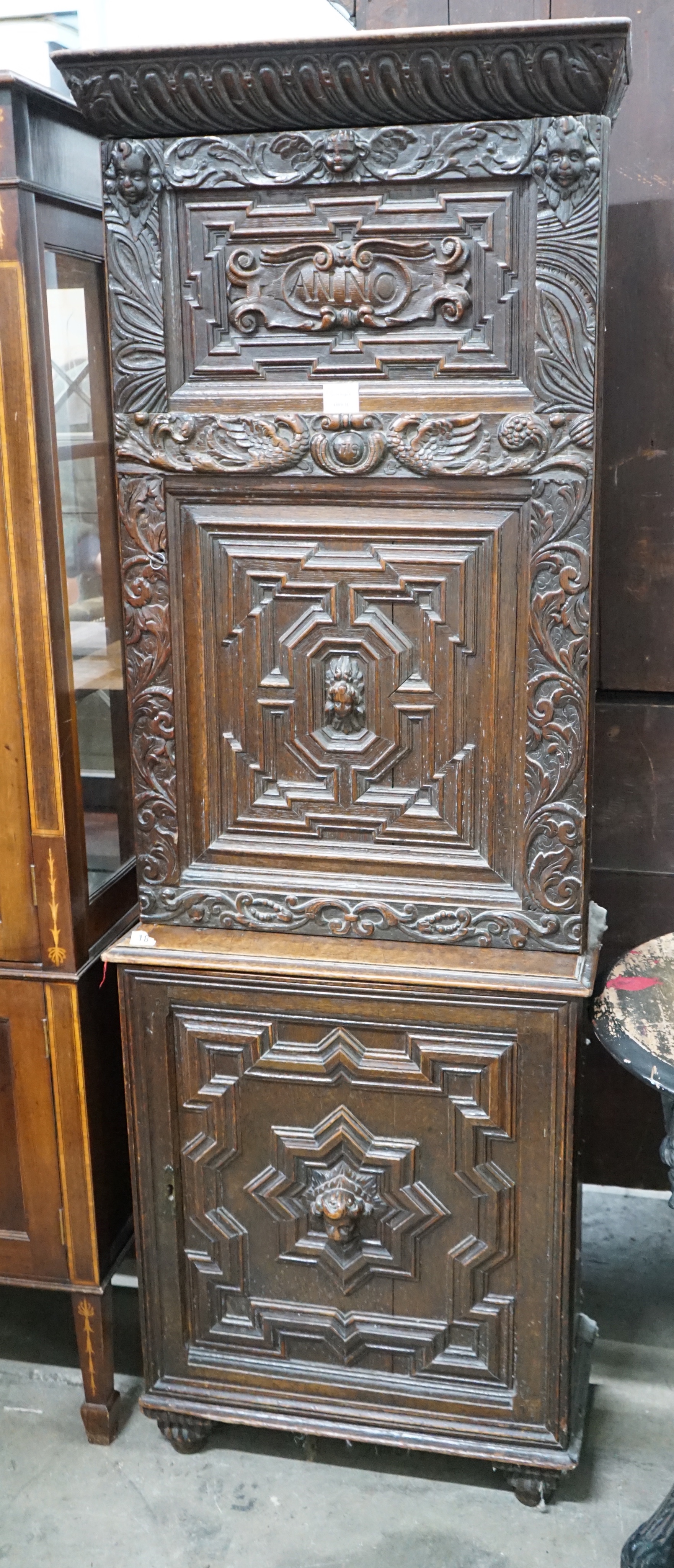 A carved oak narrow cupboard, width 60cm depth 28cm height 176cm